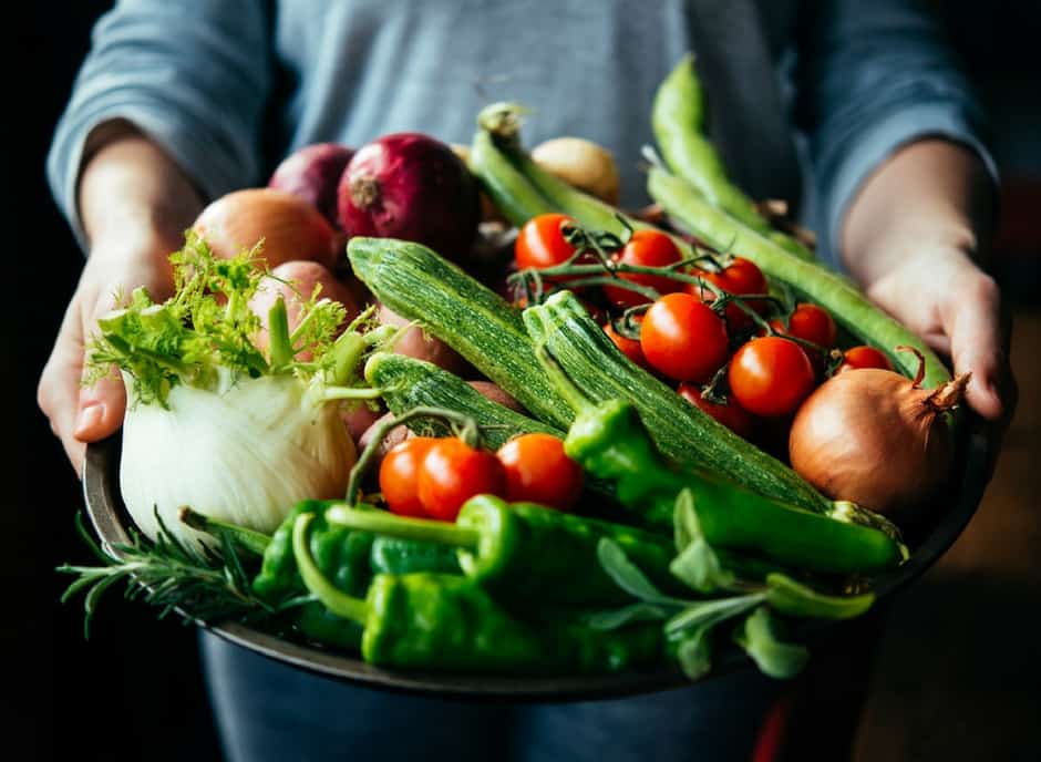 Plus Size woman holding a big bowl full of colorful vegetables 