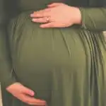 plus size pregnant woman holding her belly