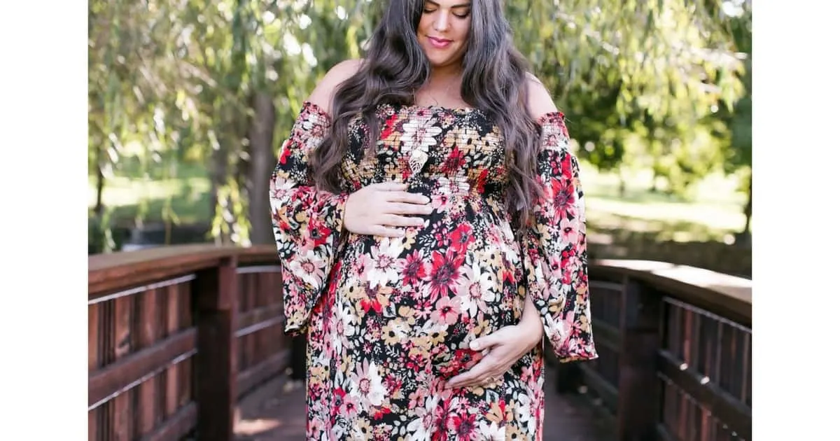 plus size pregnant woman with twins wearing a long floral dress 