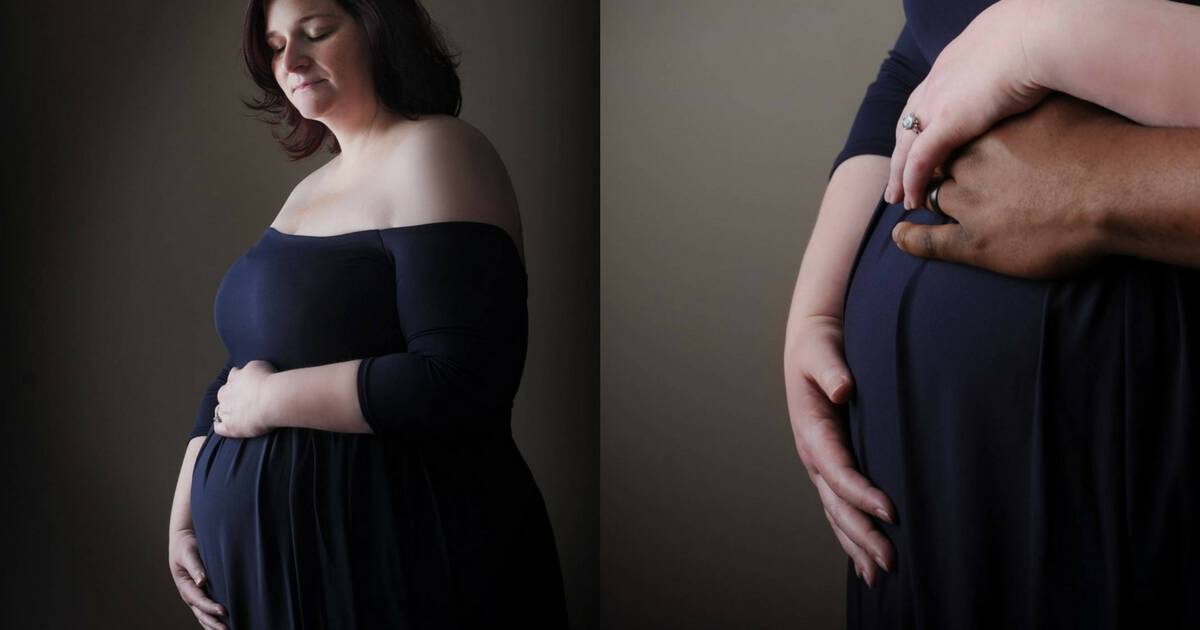 plus size pregnant woman holding her belly wearing a long purple dress 