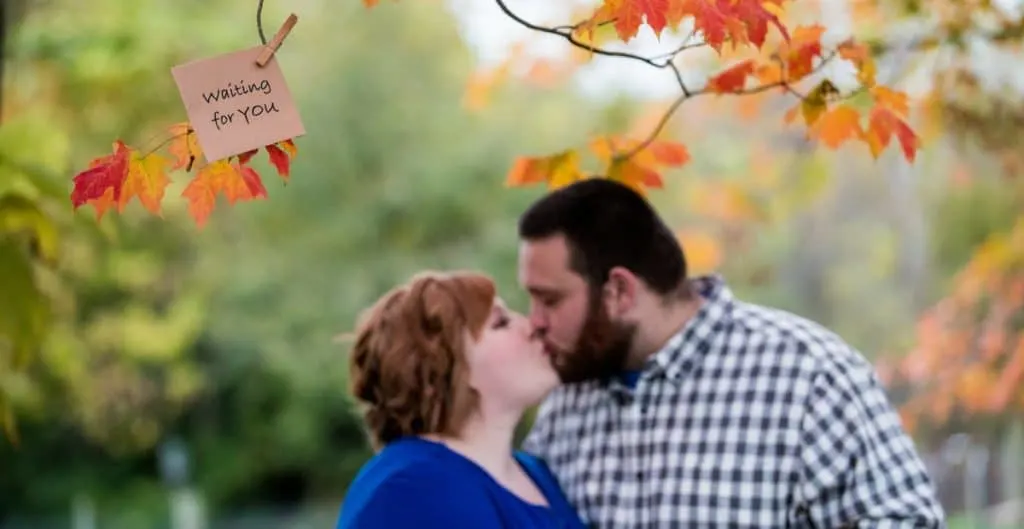 couple kissing taking adoption maternity photos 