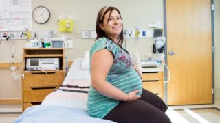 plus size pregnant woman sitting on a hospital bed