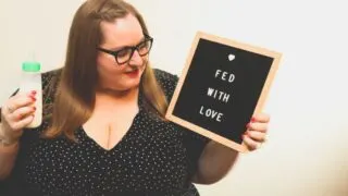plus size mother holding bottle and Fed With Love sign