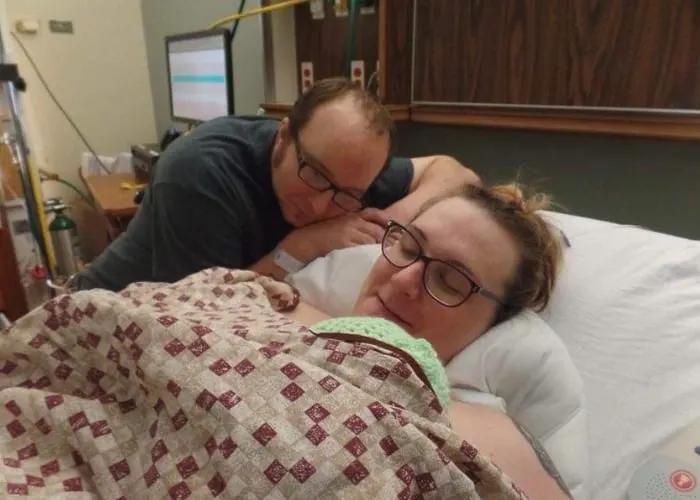 plus size woman after giving birth with her child and husband