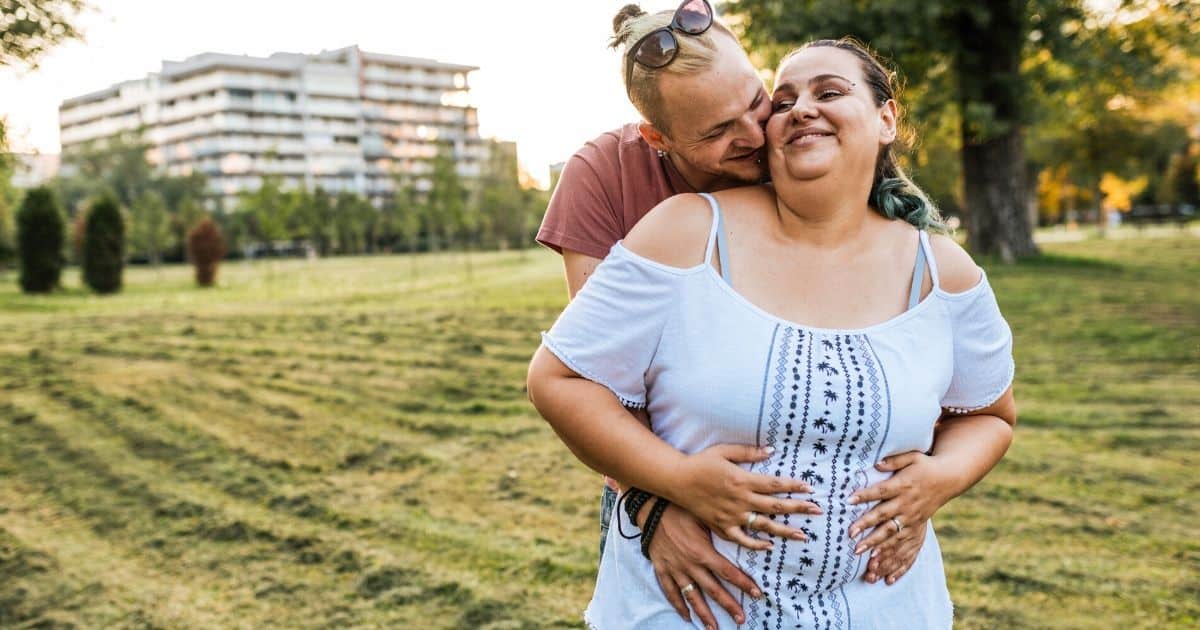 plus size vrouw die plus size is en zwanger is met haar man in een park