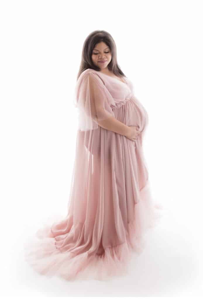 plus size maternity photo with woman wearing pink dress
