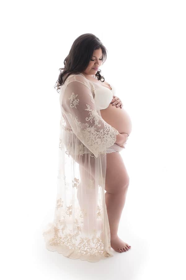 plus size woman wearing white for maternity photo shoot