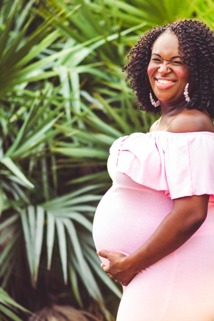 Plus Size Maternity Dresses For Photoshoot woman in pink dress pregnant and smiling 