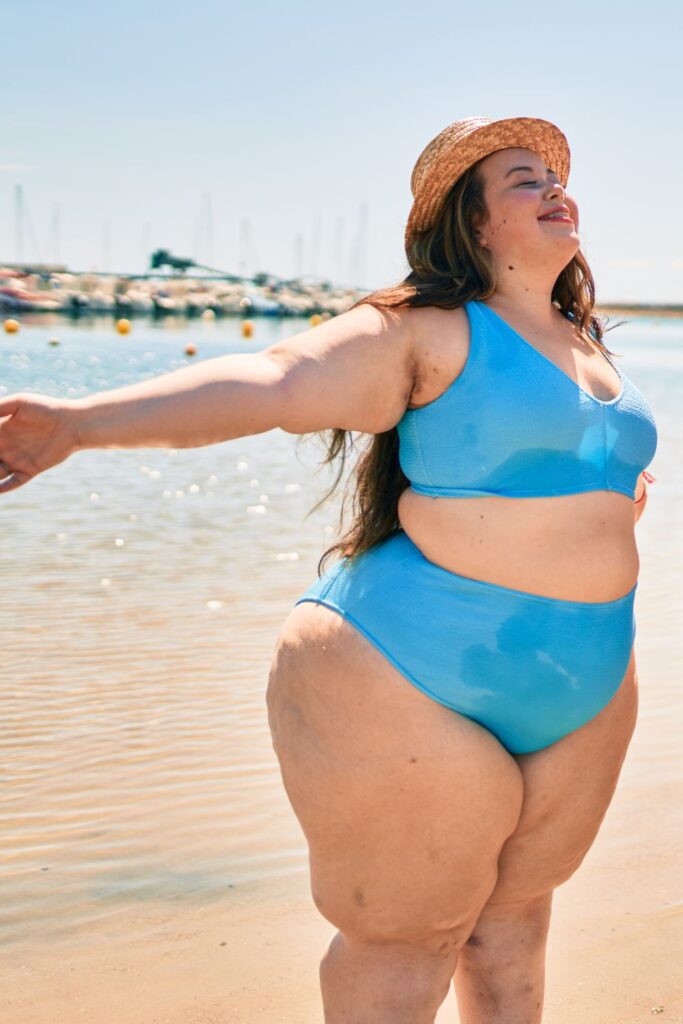 plus size woman with chub rub wearing a blue bikini