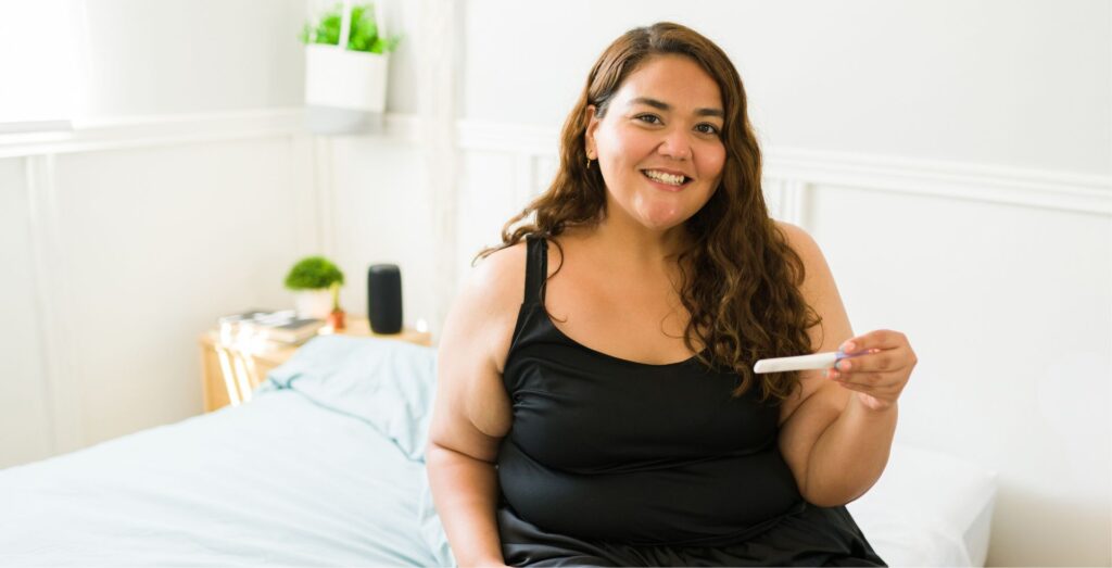 plus size woman holding a pregnancy test