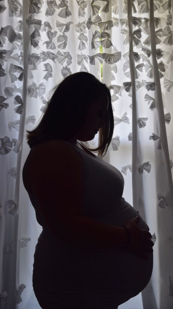 pregnant woman doing a silhouette plus size maternity pose in black and white 
